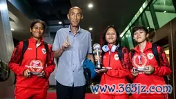 Pemain Timnas Indonesia, Laita Roati (kiri), Viny Silfianus (kedua kanan), Reva Octaviani (kanan), dan pelatih Satoru Mochizuki (kedua kiri) berpose dengan membawa trofi Piala AFF Wanita 2024 dan penghargaan individu (kiper terbaik dan pemain terbaik) saat mendarat di Gedung VVIP Terminal 3 Bandara Soekarno Hatta, Tangerang, Jumat (06/12/2024). (Bola.com/Bagaskara Lazuardi)